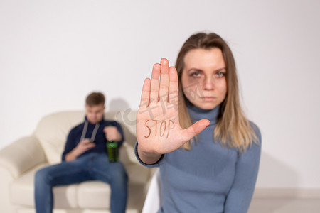 酗酒、虐待和问题概念 — 悲伤的女人显示停止标志，停止家庭暴力