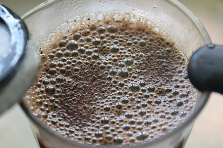在杯子里的咖啡表面关闭视图。