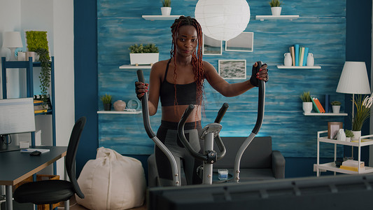 黑人女子在椭圆自行车上进行有氧运动训练