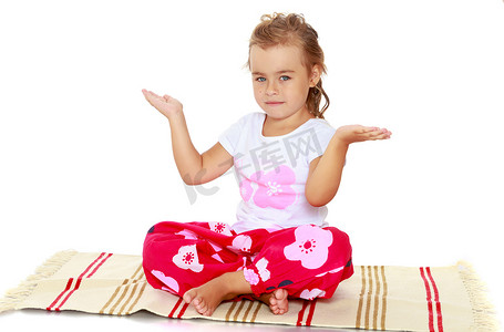 孩子冥想摄影照片_小女孩在垫子上冥想。