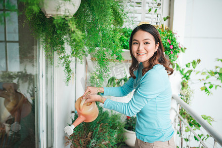 阳台花园容器中的妇女 wtering 植物