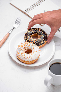大理石桌面上有甜甜圈和咖啡的快餐早餐。