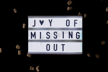 带有文本 JOMO Joy of Missing Out 的灯箱。