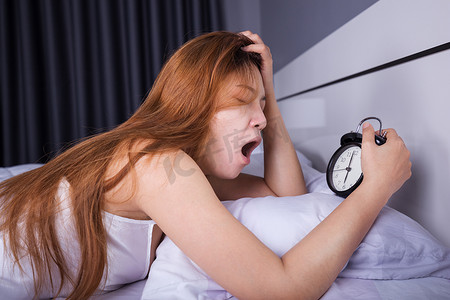 女人睡觉摄影照片_女人睡觉，早上醒来关掉闹钟
