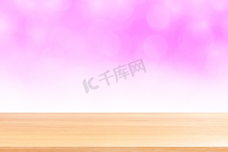 空木桌地板在模糊的散景柔和的粉红色白色渐变背景上，木板空在粉红色散景彩色浅色阴影上，彩色散景灯渐变柔和，用于横幅广告产品