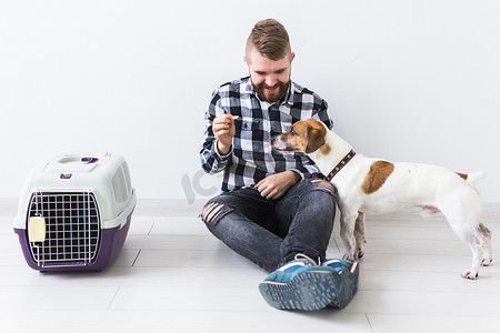狗携带包和宠物主人的概念 — 穿着格子衬衫的迷人开朗男性拥有最喜欢的宠物。