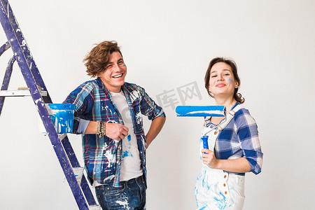 修复、翻新和爱情情侣概念 — 年轻家庭一起修复和粉刷墙壁并大笑