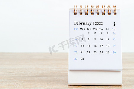 2022 年 2 月日历在木桌上。
