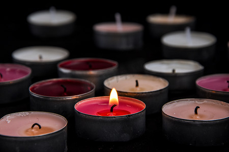 一套粉色茶蜡石蜡蜡烛躺在黑色背景上。