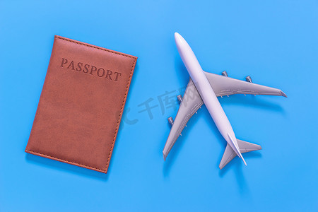 蓝色的白色玩具飞机和棕色护照保护盖