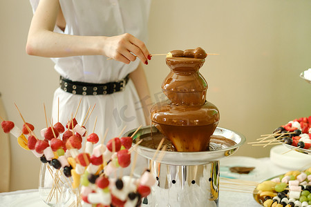 带有巧克力喷泉和糖果的火锅。甜蜜的主题