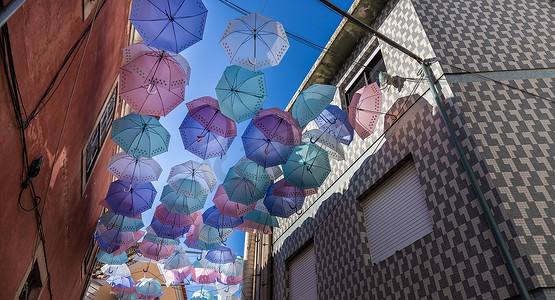 手工日晒摄影照片_葡萄牙的街头雨伞高高挂起以防雨淋和日晒