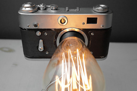 电商渐变背景摄影照片_来自旧相机的复古灯，灰色背景上有一盏爱迪生灯。