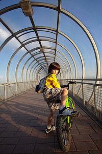 廊桥上骑自行车的男孩
