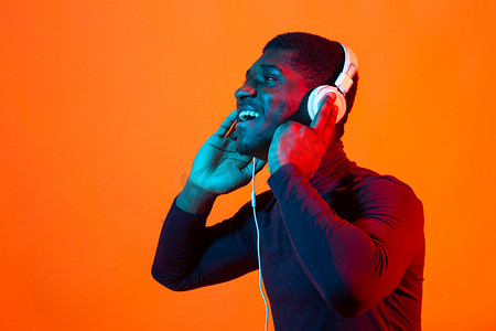 非洲年轻人戴着耳机听音乐的霓虹画像。