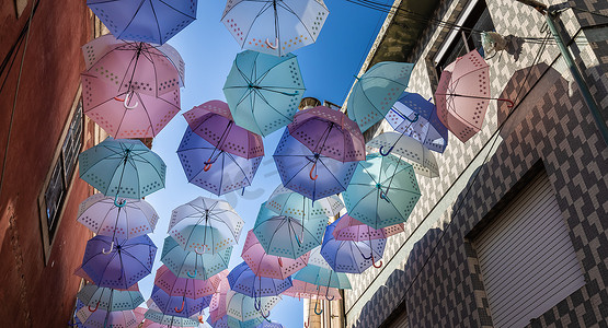 手工日晒摄影照片_葡萄牙的街头雨伞高高挂起以防雨淋和日晒