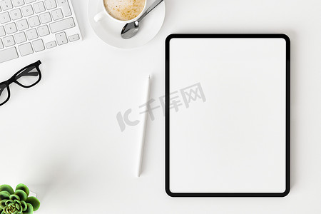 白色办公桌上空白屏幕平板电脑的顶部视图