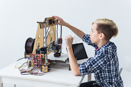 教育、儿童、技术概念-青少年男孩正在 3d 打印机上打印。