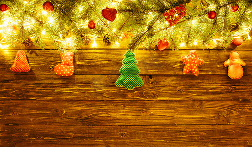 模糊的圣诞背景，棕色木板上有杉枝、仙女灯和圣诞装饰