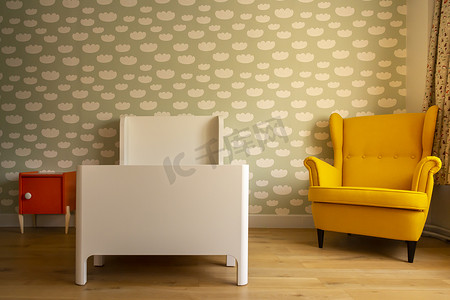 云纹花纹边框摄影照片_蹒跚学步的卧室，墙上有云纹、复古椅子、木地板和橙色床头柜