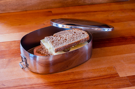 学校午餐装在木质表面的不锈钢午餐盒中