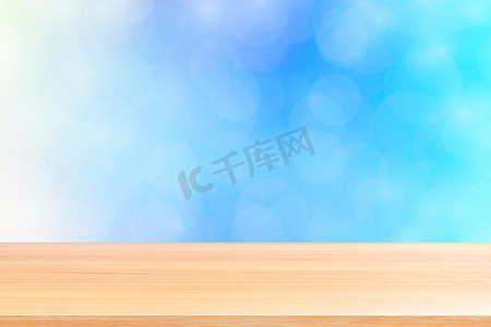 模糊的散景柔和蓝色渐变背景上的空木桌地板，蓝色散景彩色浅色上的木板空，彩色散景灯渐变蓝色柔和，用于横幅广告产品