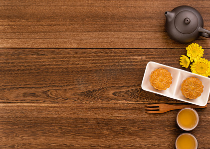 中月饼摄影照片_深色木桌上的茶月饼，中秋节传统食品布局设计的节日概念，顶视图，平躺，复制空间。