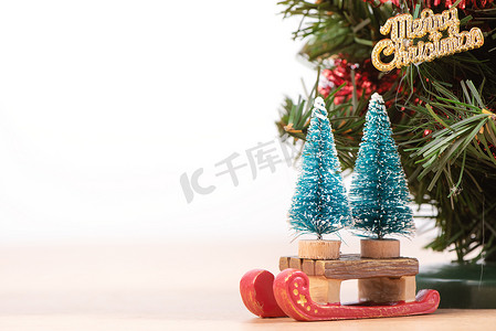 木地板上装饰着可爱的圣诞树，背景为白色，玩具为节日设计理念的空白，特写