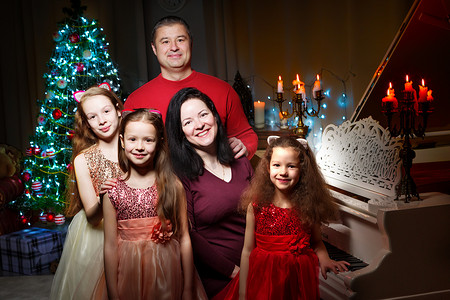 有孩子的家摄影照片_有孩子的幸福大家庭在圣诞树附近。