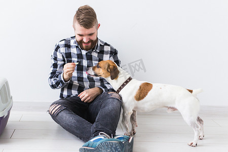 狗携带包和宠物主人的概念 — 穿着格子衬衫的迷人开朗男性拥有最喜欢的宠物。