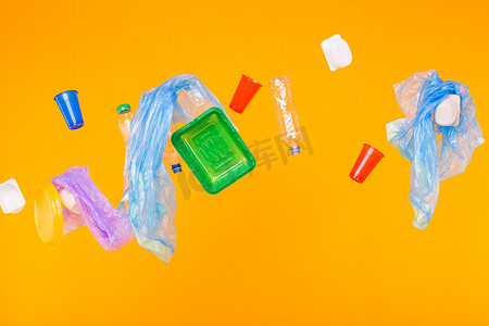 世界环境日、塑料回收问题和环境灾难概念-黄色背景中的塑料垃圾