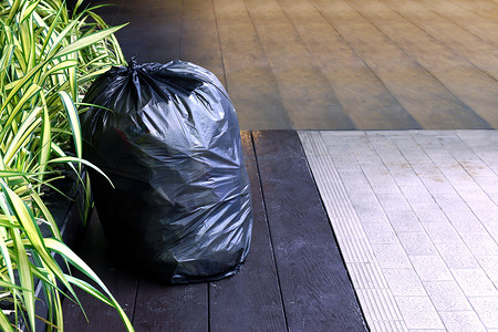 废塑料袋，地板上的垃圾袋塑料黑色，垃圾，垃圾，垃圾箱，废塑料污染，人行道上的废物