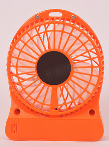 橙色扇形摄影照片_橙色迷你风扇，白色背景中的便携式风扇 USB