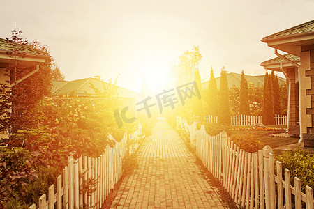 小屋和花园之间的人行道到初升的太阳。
