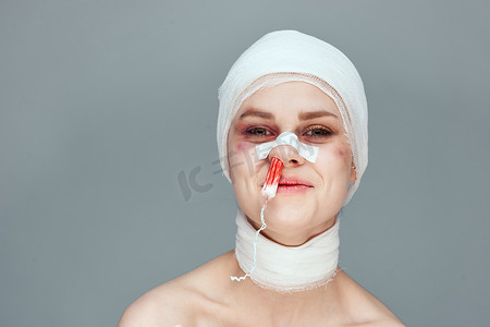 割腕血迹摄影照片_鼻子里有血迹的妇女卫生棉条,脸部受伤,背景孤立