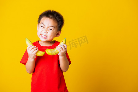 孩子或小孩可爱的小男孩迷人的微笑玩耍拿着香蕉