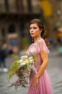 意大利佛罗伦萨老城中心，一位身穿粉色连衣裙、手捧花束的新娘
