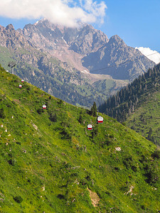 通往山脉的公路摄影照片_阿拉木图 - 山脉和通往 Shymbulak 滑雪胜地的索道