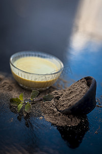 Ayurvedic 草本 brahmi 或 Waterhyssop，将其有益的糊状物放入玻璃碗中，并在木质表面上涂上粉末。