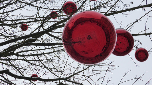 红色小雪花摄影照片_挂在树上的圣诞红色玩具。