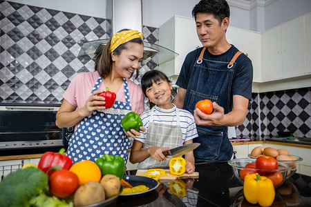 cooking摄影照片_幸福的家庭有爸爸、妈妈和他们的小女儿 Cooking Tog