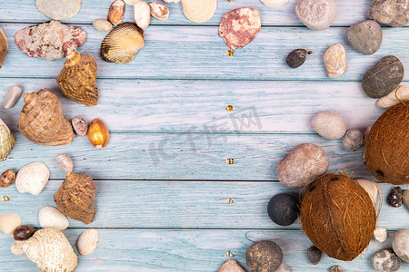 蓝色木质背景上的椰子、岩石和贝壳。海洋主题