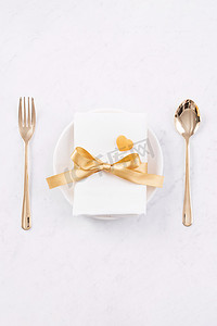 浪漫情人节促销摄影照片_情人节餐设计理念-浪漫的盘子设置隔离在大理石白色背景上，用于餐厅节日庆典促销、顶视图、平躺。