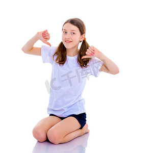 小女生指着她空的白色 t 恤。