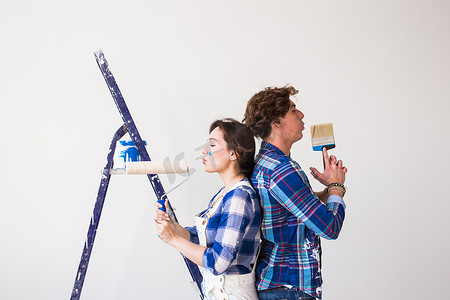 团队合作、维修和翻新概念 — 新公寓里被油漆覆盖的男人和女人