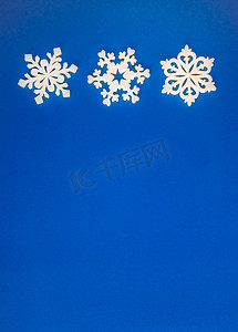 海蓝背景摄影照片_圣诞假期作文，蓝色海蓝宝石背景上的顶视图白色雪花装饰，带有文本复制空间。