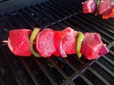 青椒牛肉摄影照片_烧烤架上木棍上的牛肉和胡椒