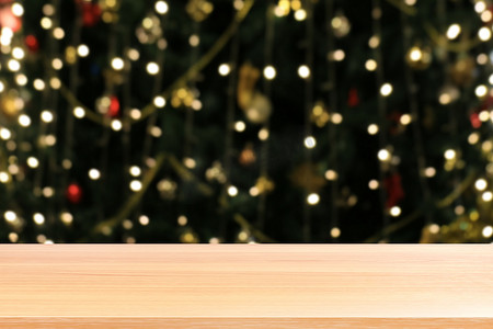 木板照明模糊圣诞树装饰背景，空木桌地板照明绿色圣诞散景，木桌板空前绿色闪光背景浅色