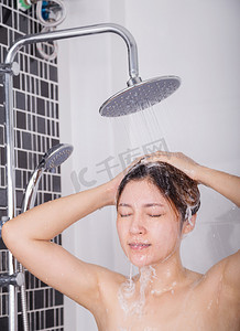女人在雨淋中用洗发水洗头和头发