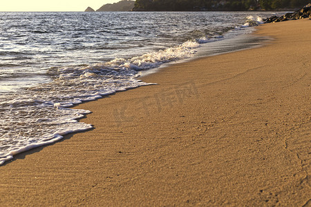 沙滩背景摄影照片_顶视图 软波从海上来到湿沙滩背景。 